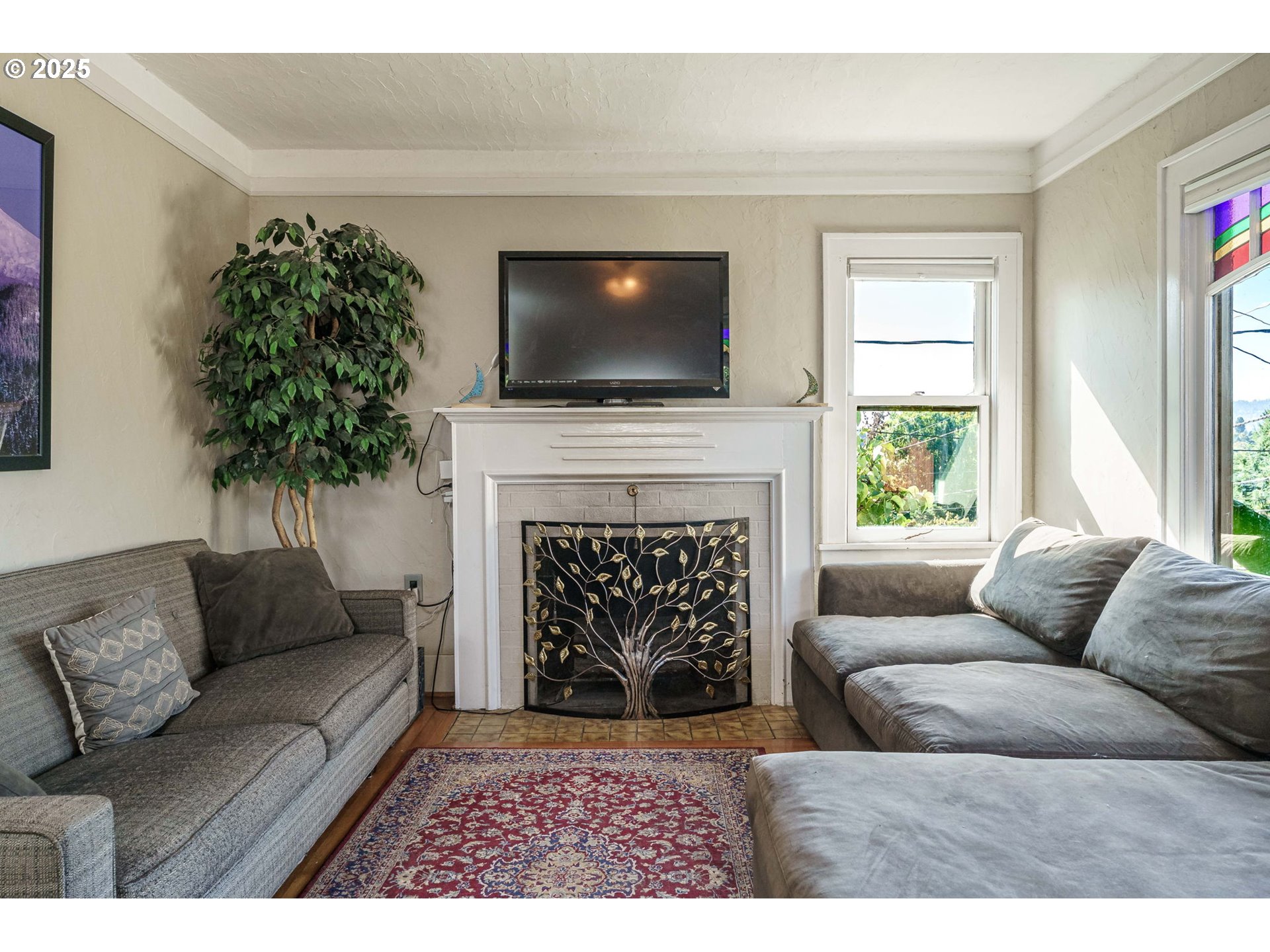 4216 Northeast 18th Avenue Portland, OR 97211 - Photo 4 of 46 a living room with furniture a flat screen tv and a fireplace
