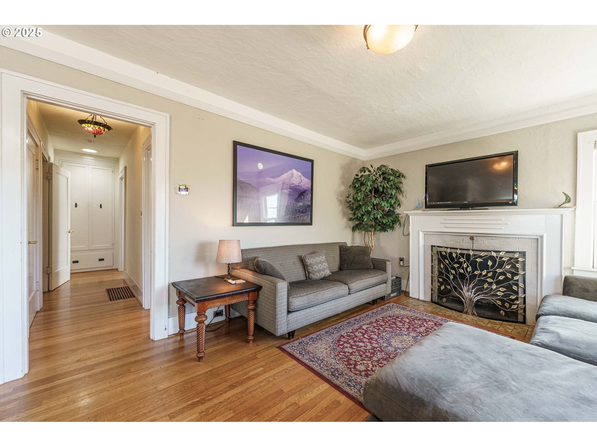 4216 Northeast 18th Avenue Portland, OR 97211 - Photo 6 of 46 a living room with furniture a flat screen tv and a fireplace
