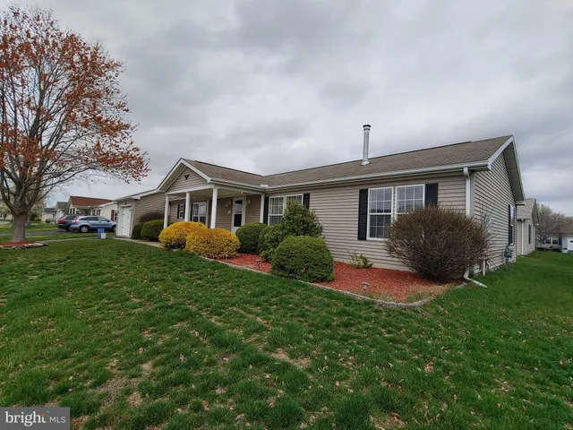 a front view of a house with a yard and potted plants