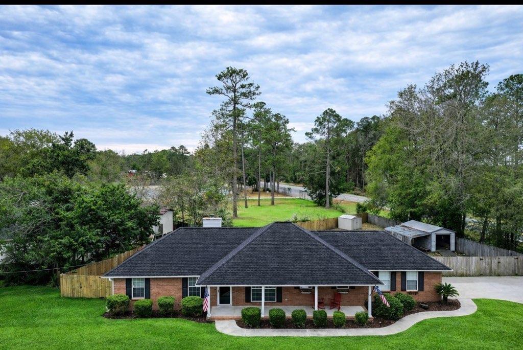 a aerial view of a house with a big yard and large trees
