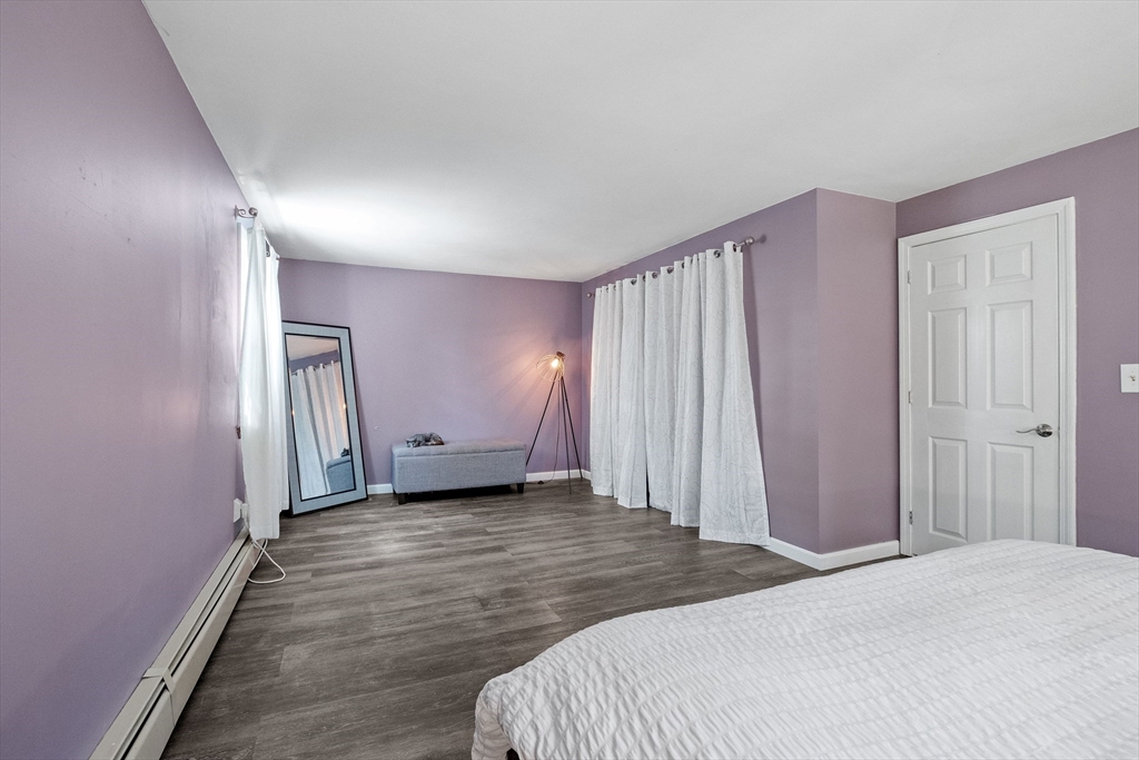 54 Alpine Street Milford, NH 03055 - Photo 17 of 33 a spacious bedroom with a bed and a mirror