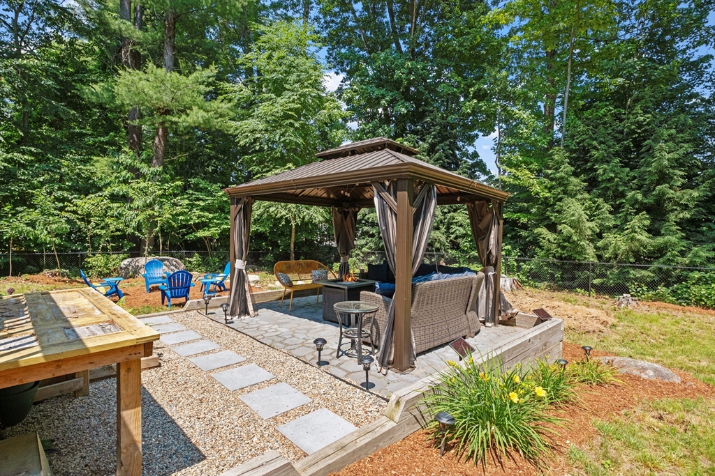 54 Alpine Street Milford, NH 03055 - Photo 30 of 33 an outdoor space with furniture and umbrella
