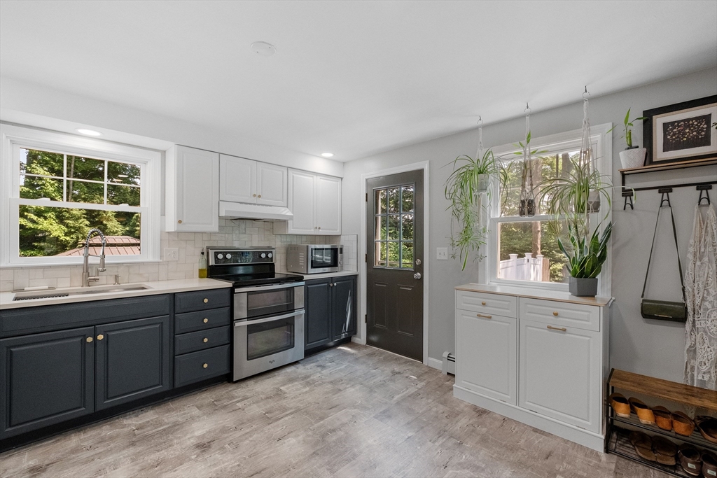54 Alpine Street Milford, NH 03055 - Photo 8 of 33 a kitchen with stainless steel appliances granite countertop a stove and a refrigerator