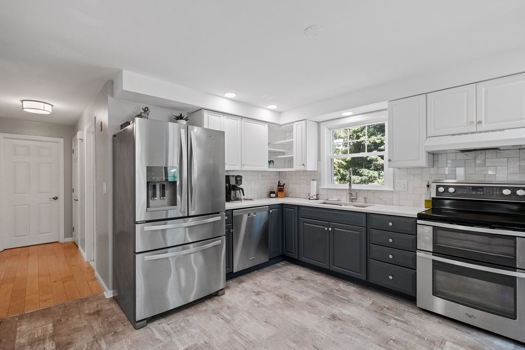 54 Alpine Street Milford, NH 03055 - Photo 9 of 33 a kitchen with stainless steel appliances granite countertop a refrigerator and a stove top oven