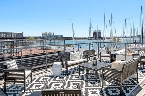 a roof deck with couches and wooden floor