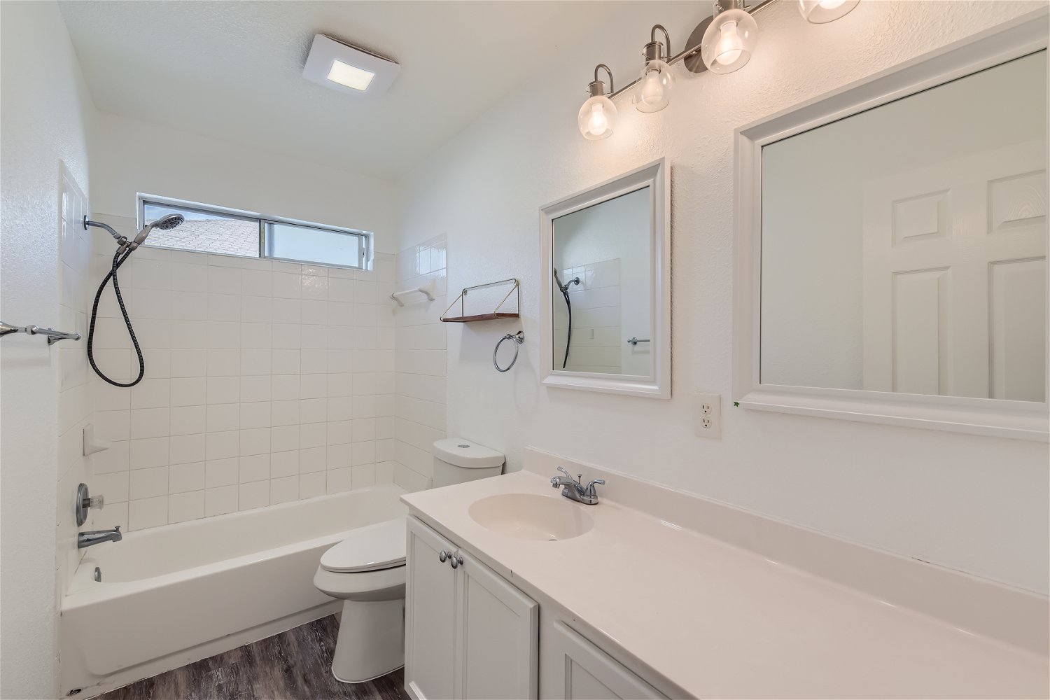 115 Killian Loop Hutto, TX 78634 - Photo 9 of 14 Well-lit bathroom features a white tiled shower/tub combo and a clean vanity with a single sink.