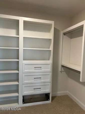 a view of walk in closet with empty racks