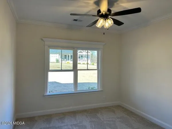 an empty room with a window and a fan