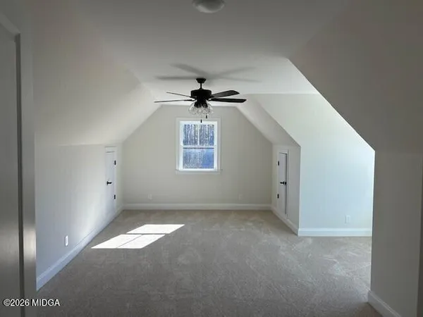 en empty room with windows and ceiling fan