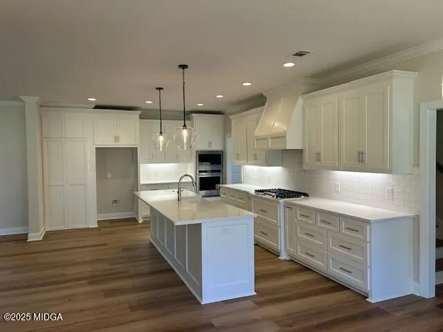 a large kitchen with stainless steel appliances a large counter top a stove and a refrigerator