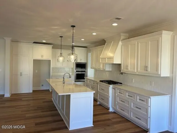 a kitchen with kitchen island granite countertop a sink stove and refrigerator