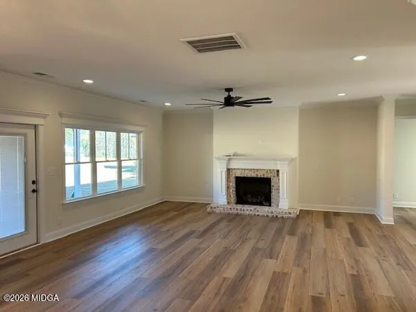 a view of an empty room with a fireplace and a window