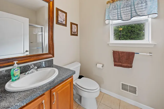a bathroom with a granite countertop sink a toilet and a mirror