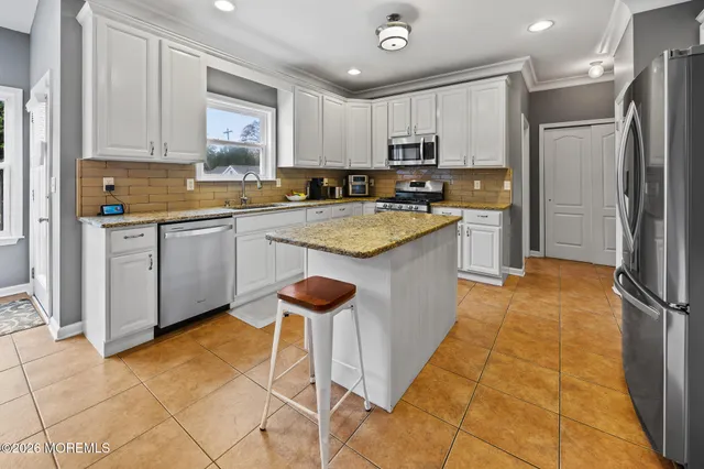 a kitchen with stainless steel appliances granite countertop a stove refrigerator sink and cabinets