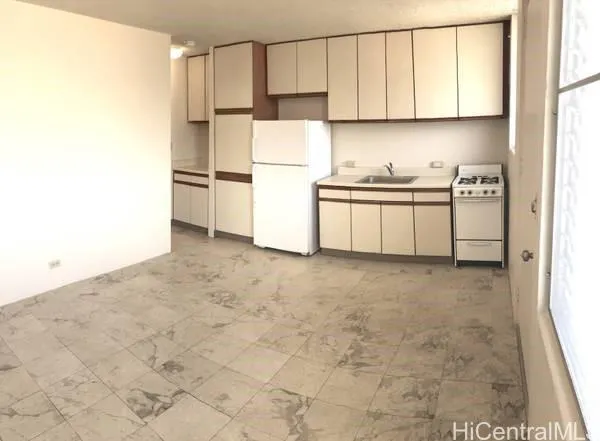 a kitchen with a refrigerator and white cabinets