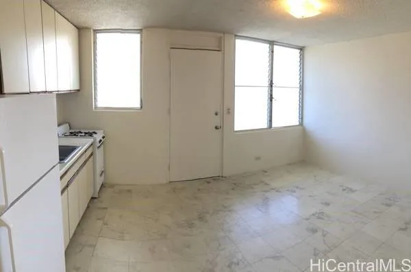 a view of a kitchen with wooden floor and a window