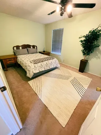 a bedroom with a bed and a potted plant