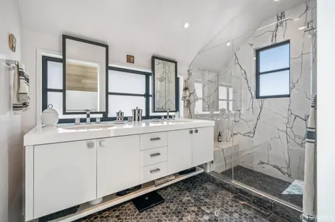 a bathroom with double sink and a mirror