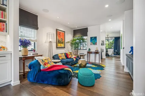 a living room with furniture and a wooden floor