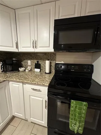 a kitchen with stainless steel appliances granite countertop a stove microwave and cabinets