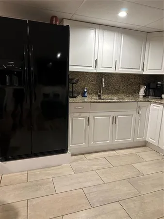 a bathroom with a granite countertop sink and cabinets