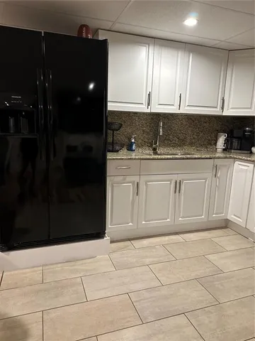a bathroom with a granite countertop sink and cabinets