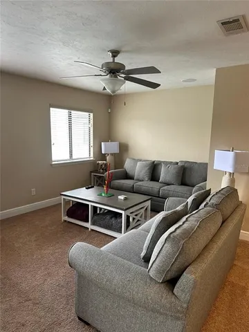 a living room with furniture and a ceiling fan