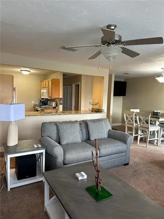 a living room with furniture and a large mirror next to a window