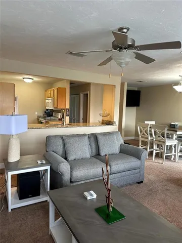 a living room with furniture and a large mirror next to a window