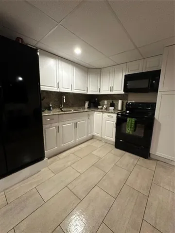 a open kitchen with stainless steel appliances granite countertop a refrigerator and a sink