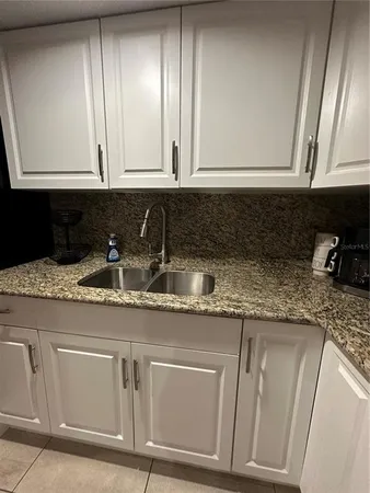 a kitchen with granite countertop stainless steel appliances white cabinets sink and dishwasher