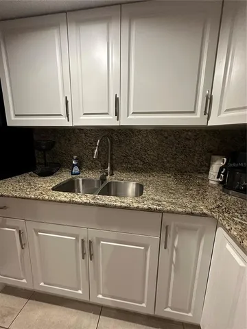 a kitchen with granite countertop stainless steel appliances white cabinets sink and dishwasher