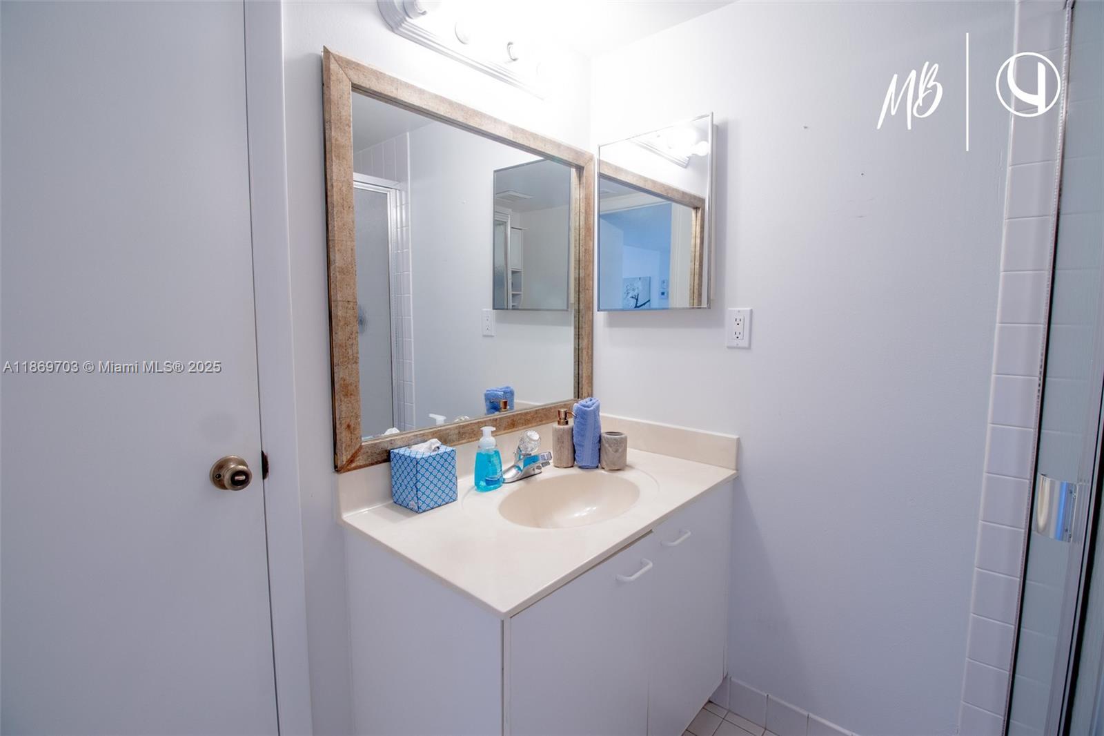 17801 North Bay Road, Unit 410 Sunny Isles Beach, FL 33160 - Photo 2 of 24 a bathroom with a sink a mirror and vanity