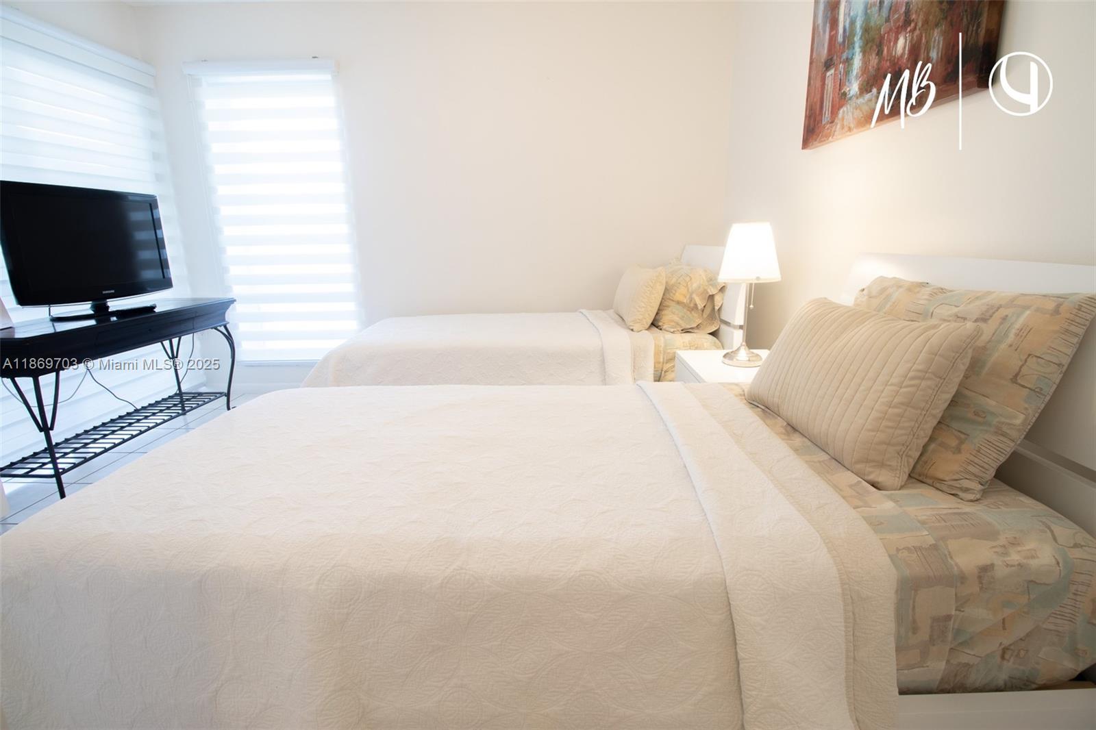 17801 North Bay Road, Unit 410 Sunny Isles Beach, FL 33160 - Photo 21 of 24 a spacious bedroom with a bed and a flat screen tv