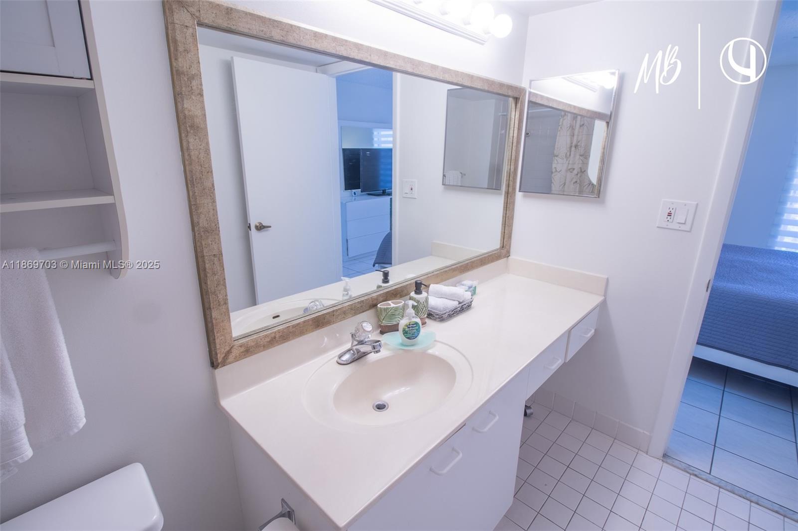 17801 North Bay Road, Unit 410 Sunny Isles Beach, FL 33160 - Photo 4 of 24 a bathroom with a sink a toilet and a mirror