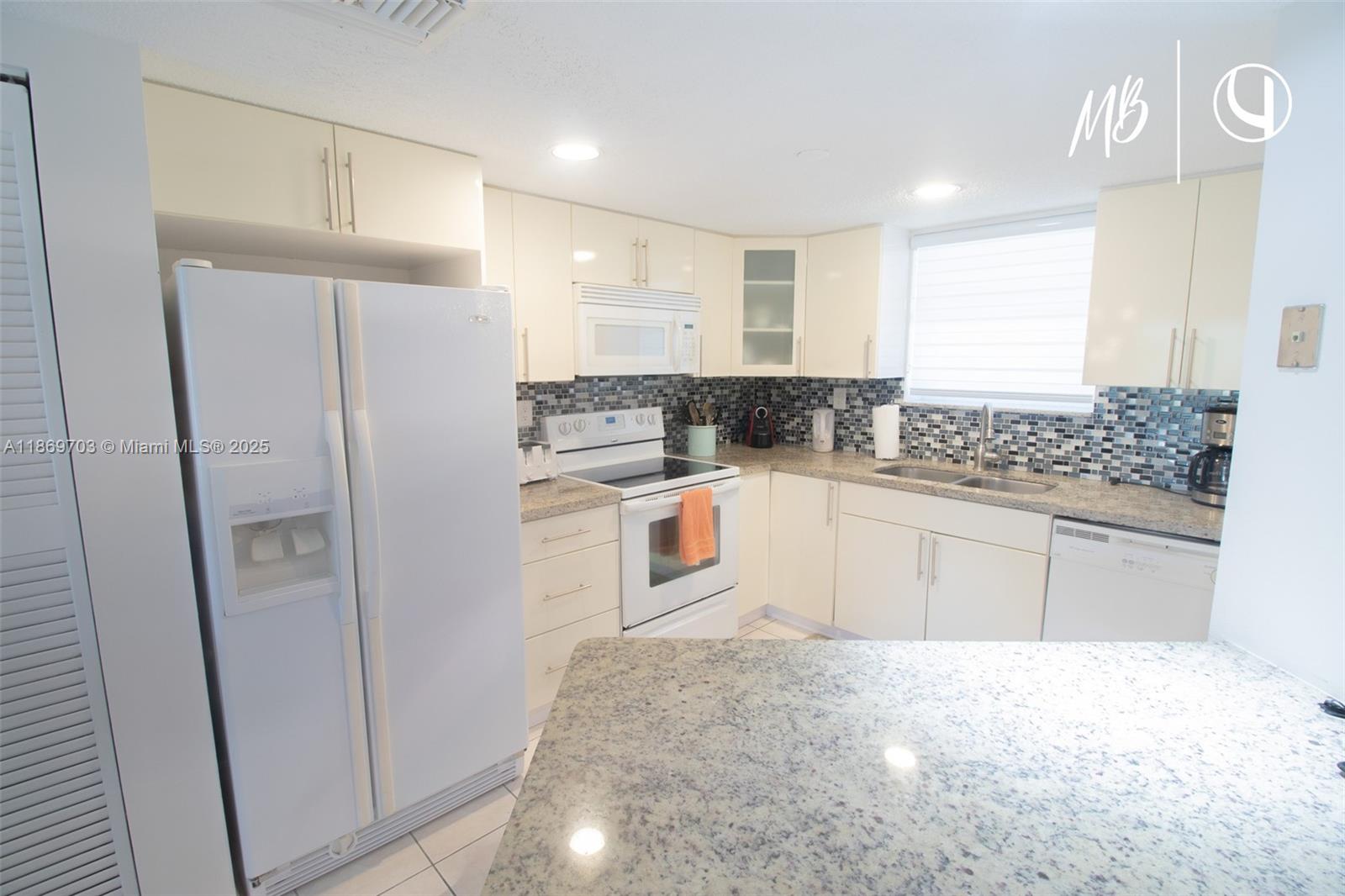 17801 North Bay Road, Unit 410 Sunny Isles Beach, FL 33160 - Photo 8 of 24 a kitchen with stainless steel appliances a refrigerator and a stove top oven