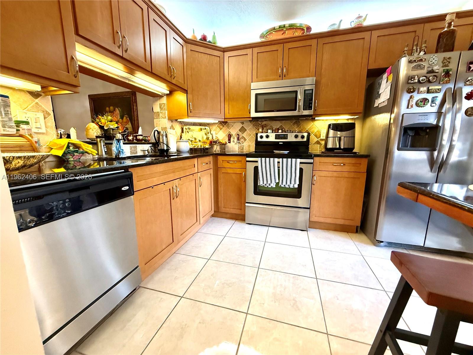 351 Club Circle, Unit 102 Boca Raton, FL 33487 - Photo 8 of 34 a kitchen with stainless steel appliances a stove a sink and a microwave
