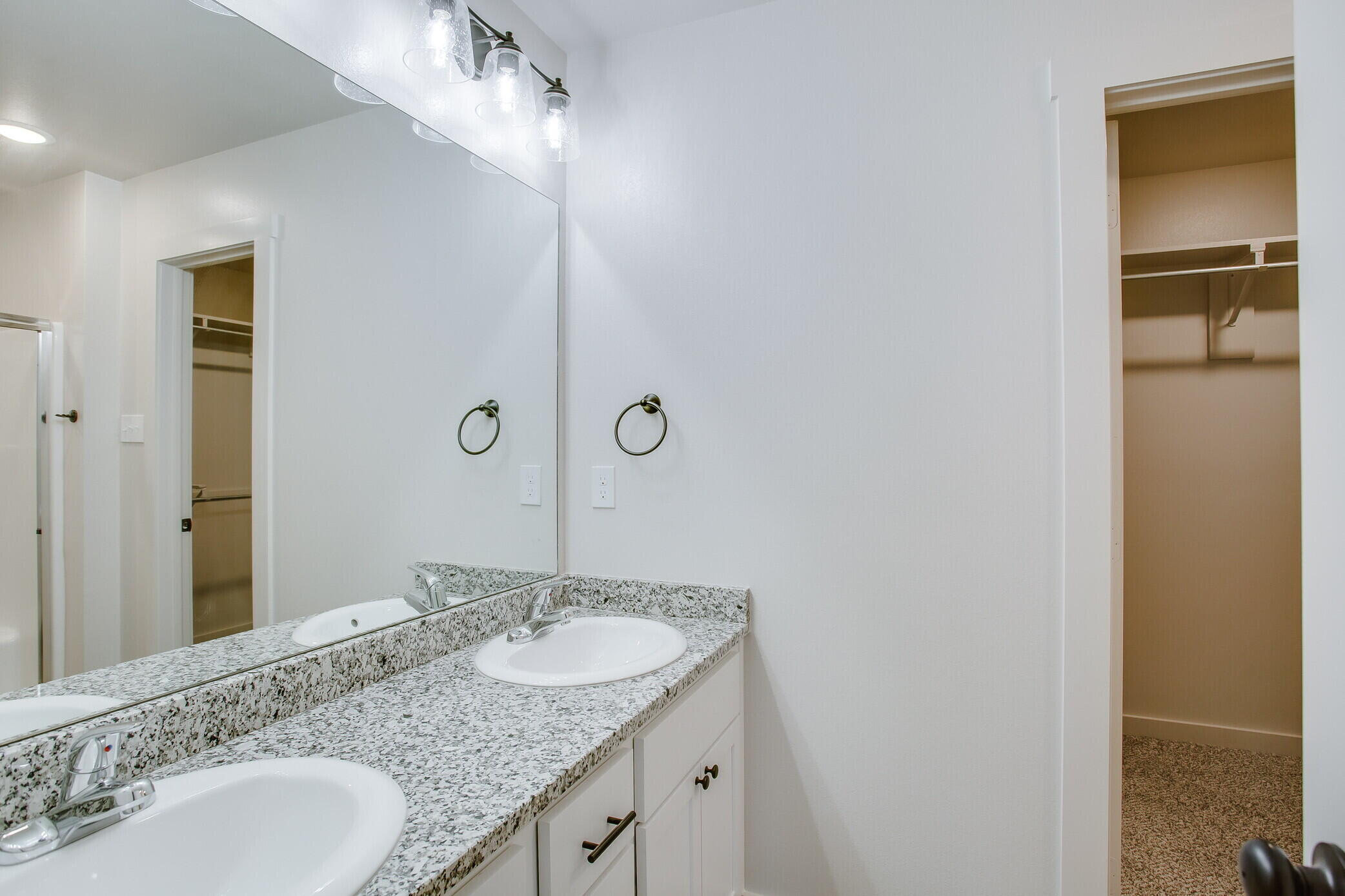 5515 121st Street, Unit B Lubbock, TX 79424 - Photo 11 of 15 a bathroom with a granite countertop sink and a mirror