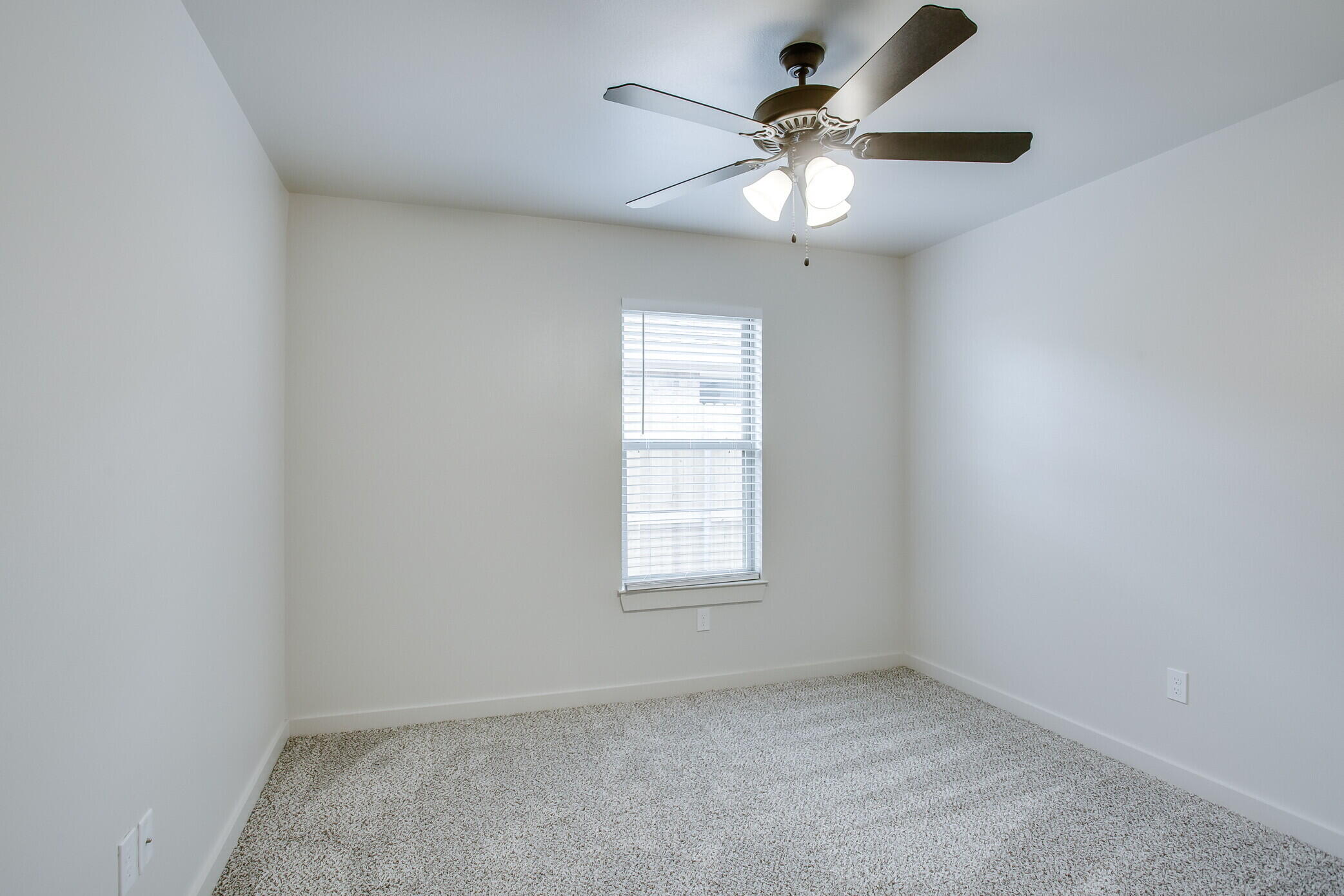 5515 121st Street, Unit B Lubbock, TX 79424 - Photo 12 of 15 an empty room with a window and a fan