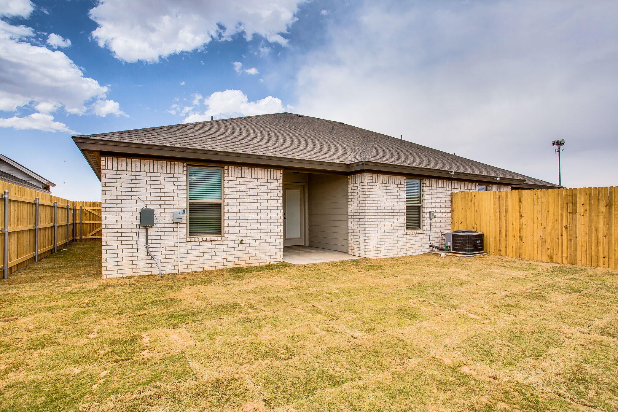 5515 121st Street, Unit B Lubbock, TX 79424 - Photo 15 of 15 a big house with large windows and a big yard