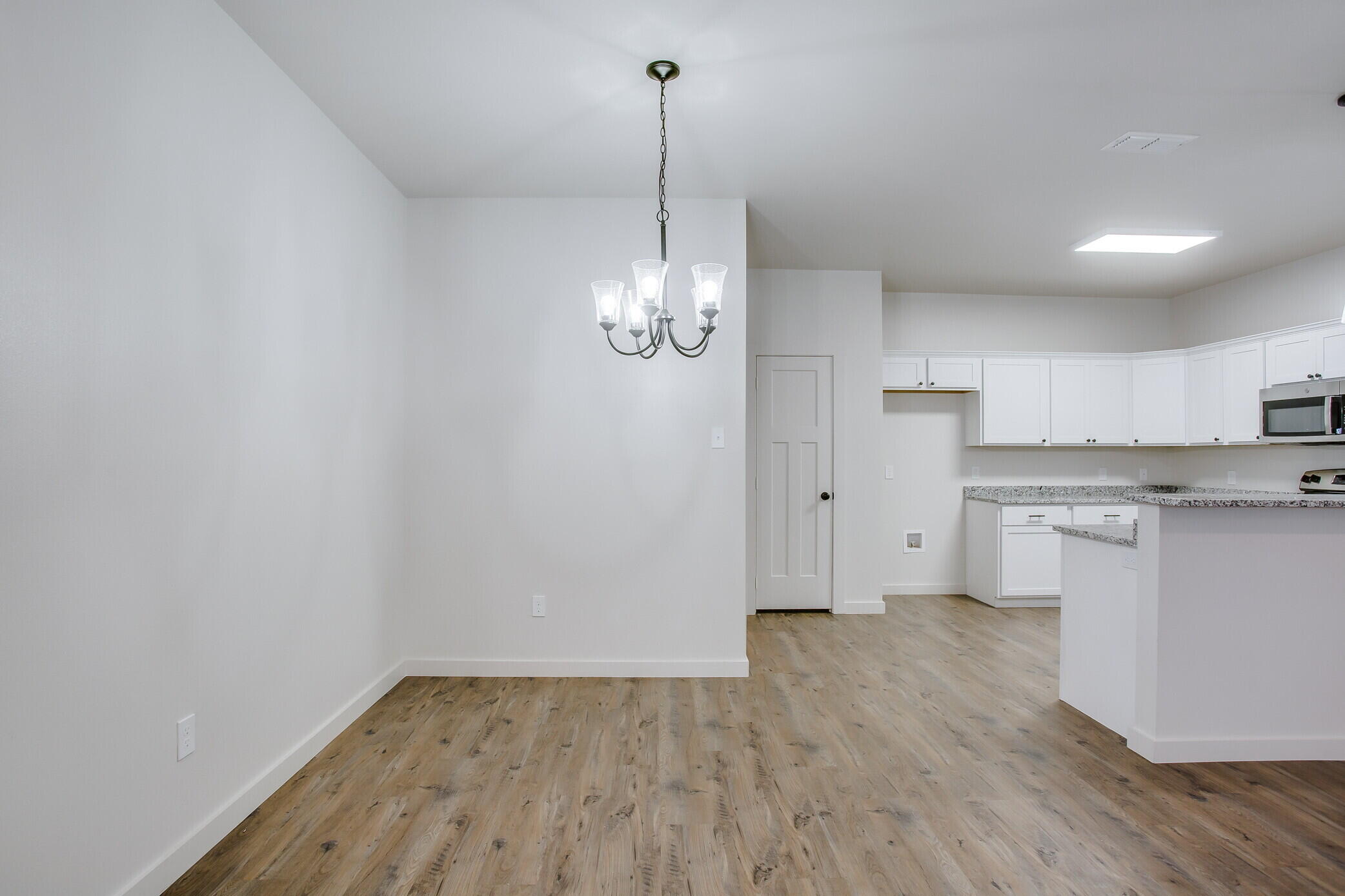 5515 121st Street, Unit B Lubbock, TX 79424 - Photo 5 of 15 a view of a kitchen with wooden floor and a sink