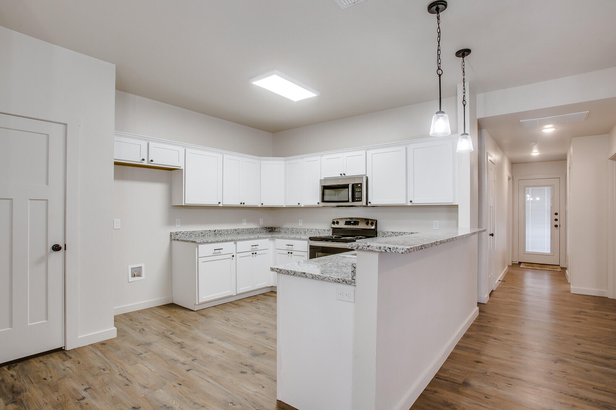 5515 121st Street, Unit B Lubbock, TX 79424 - Photo 6 of 15 a kitchen with stainless steel appliances a stove top oven a sink a refrigerator a center island and cabinets
