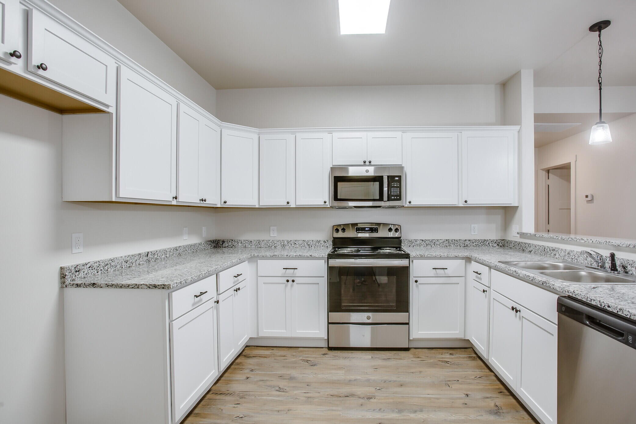5515 121st Street, Unit B Lubbock, TX 79424 - Photo 7 of 15 a kitchen with stainless steel appliances granite countertop a stove a sink and a white cabinets