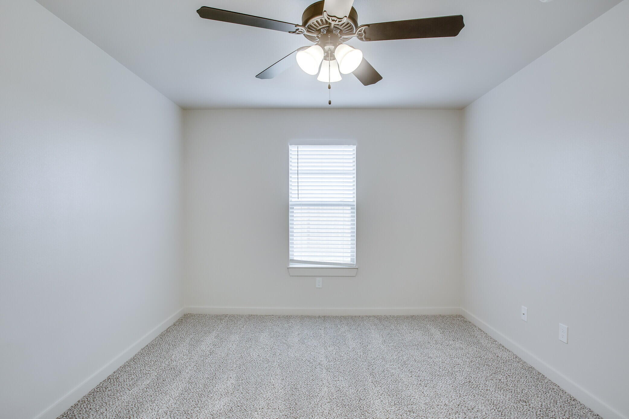 5515 121st Street, Unit B Lubbock, TX 79424 - Photo 9 of 15 an empty room with a window and a chandelier fan