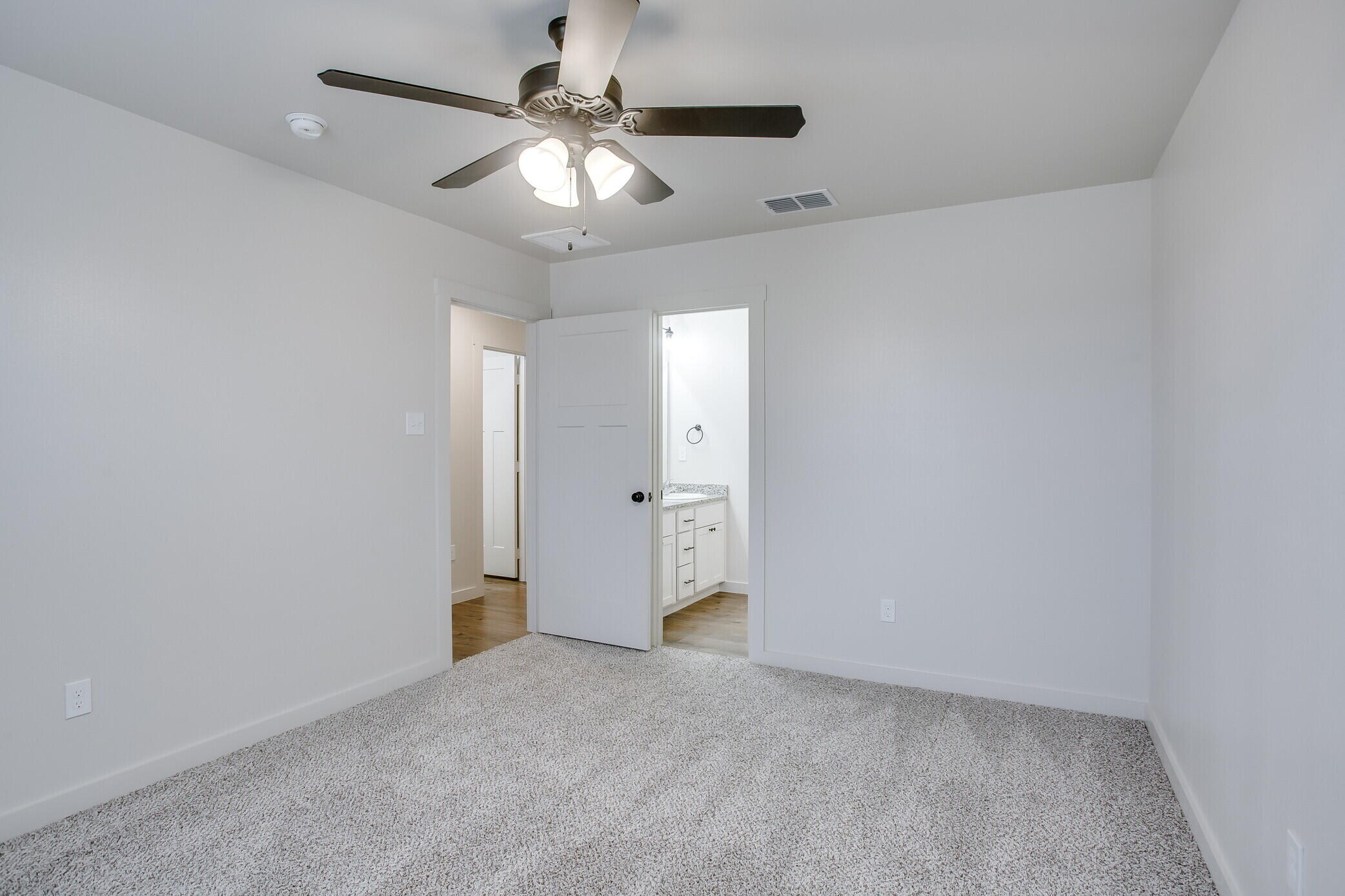 5515 121st Street, Unit B Lubbock, TX 79424 - Photo 10 of 15 an empty room with a chandelier fan and a ceiling fan