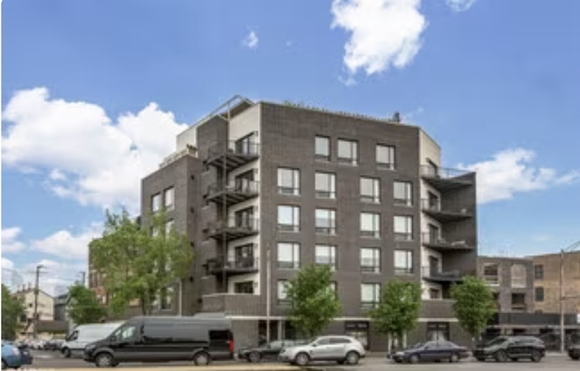 1157 West Erie Street, Unit 5W Chicago, IL 60642 - Photo 1 of 30 a front view of a building with lot of cars and trees