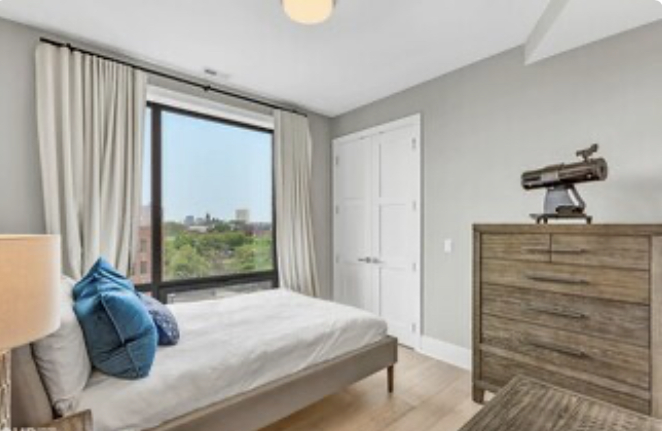 1157 West Erie Street, Unit 5W Chicago, IL 60642 - Photo 25 of 30 a bed sitting in a bedroom next to a window