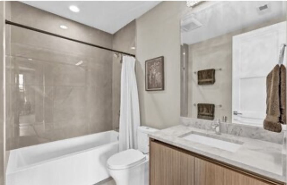 1157 West Erie Street, Unit 5W Chicago, IL 60642 - Photo 27 of 30 a bathroom with a granite countertop sink a toilet and shower