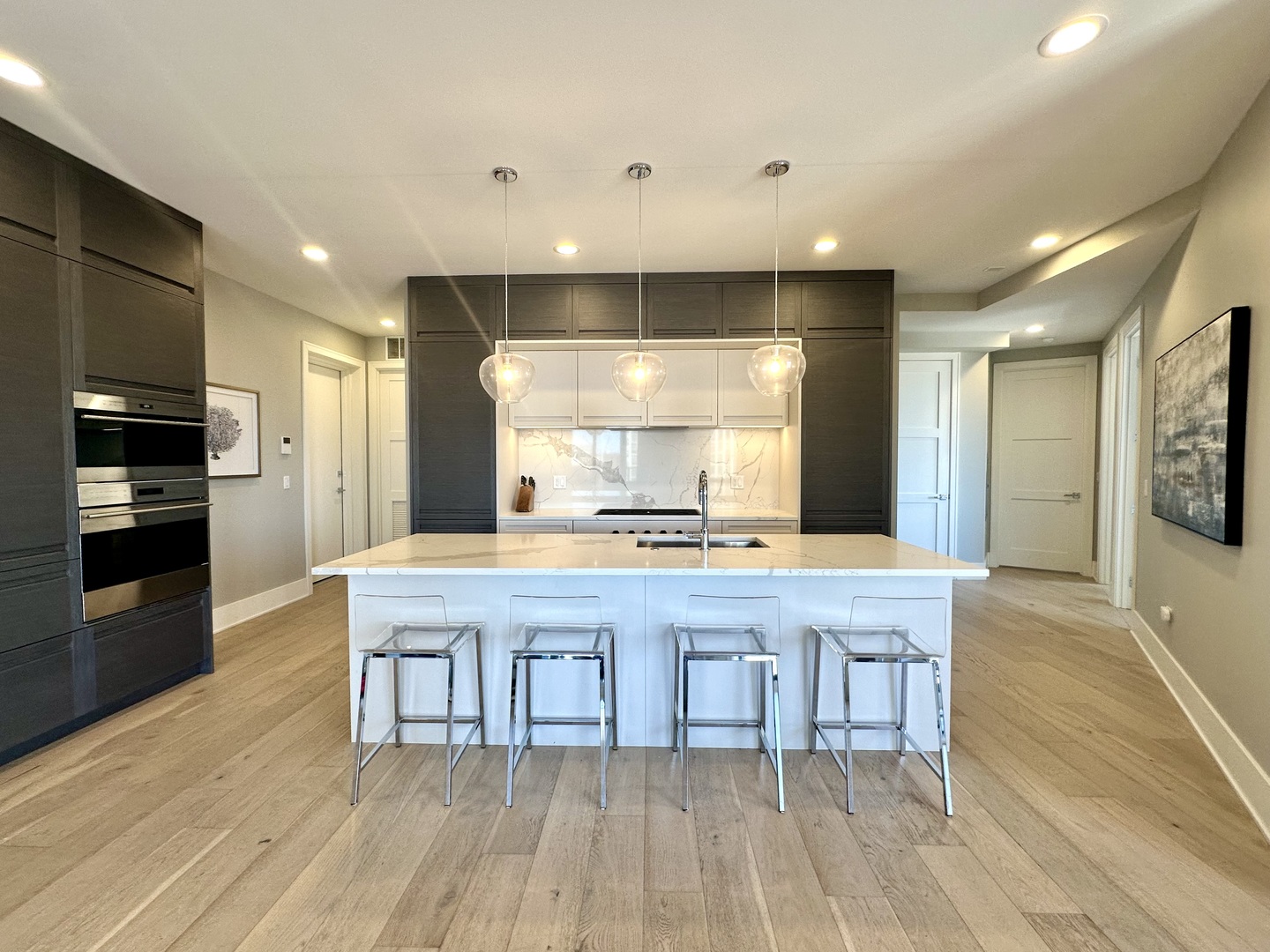 1157 West Erie Street, Unit 5W Chicago, IL 60642 - Photo 6 of 30 a kitchen with kitchen island granite countertop wooden floors and stainless steel appliances