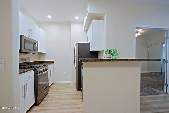 a kitchen with granite countertop a sink stove and refrigerator